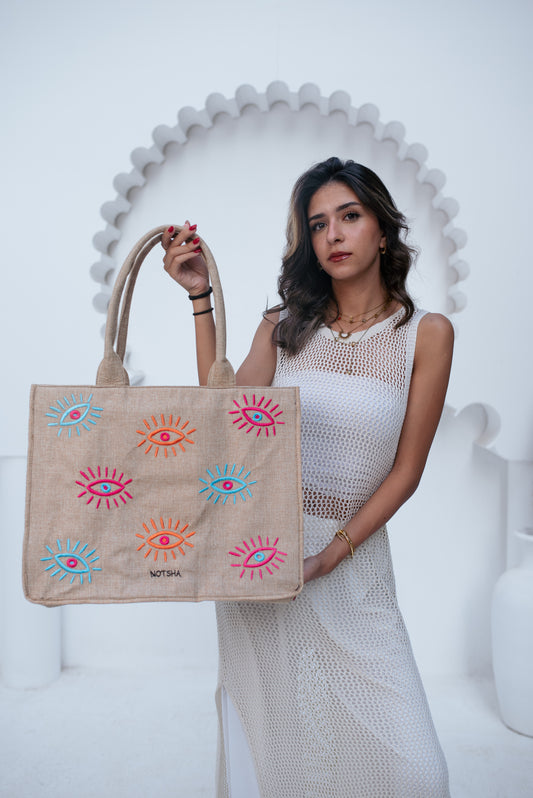 A modern twist on the classic evil eye blending baby blue, orange, and fuchsia.