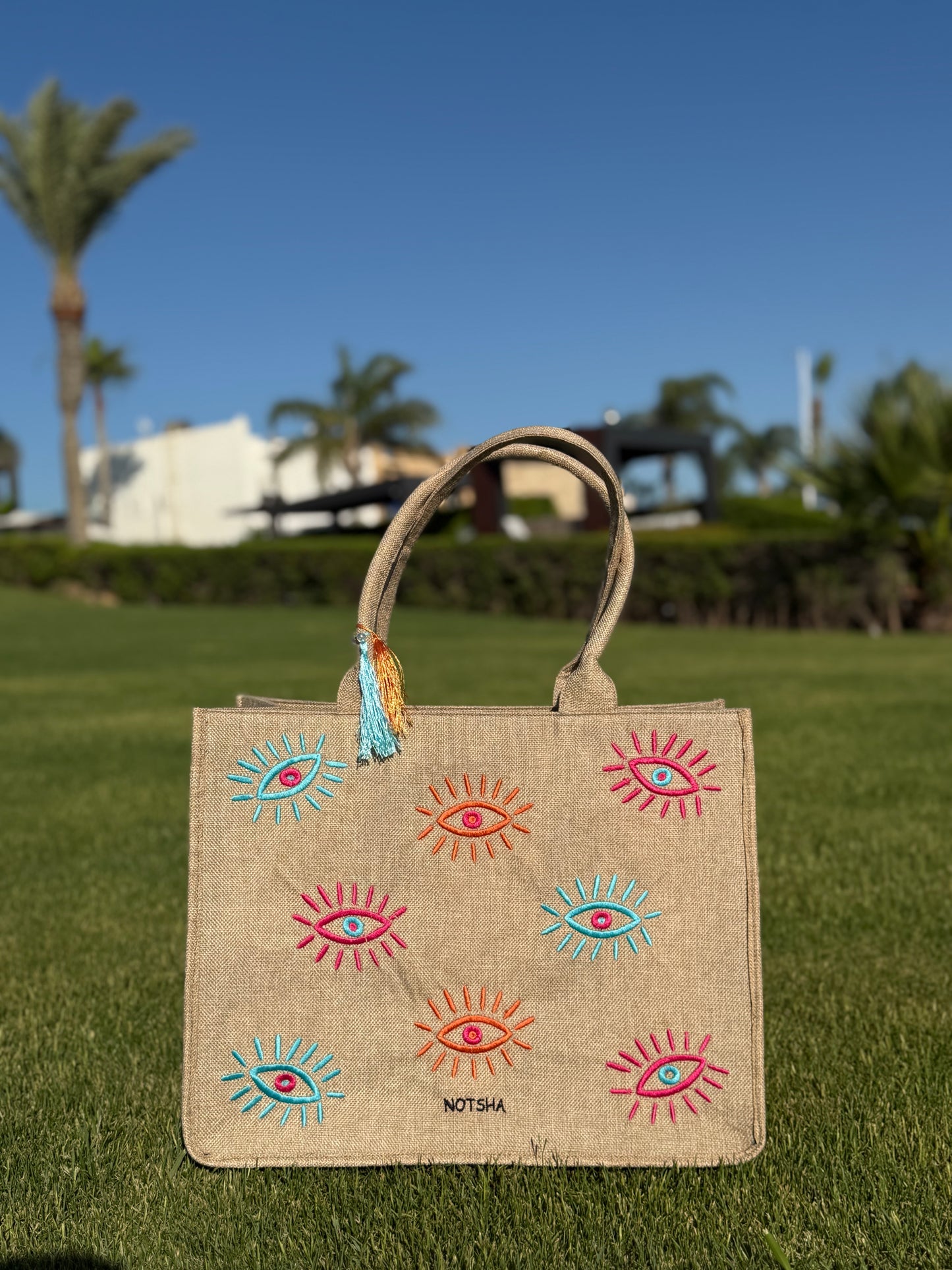 A modern twist on the classic evil eye blending baby blue, orange, and fuchsia.