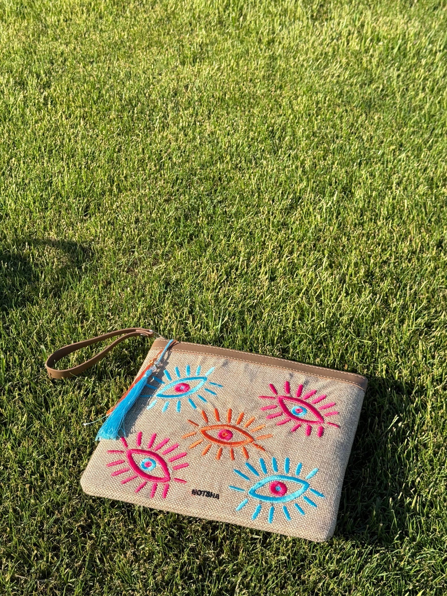 A modern twist on the classic evil eye blending baby blue, orange, and fuchsia.