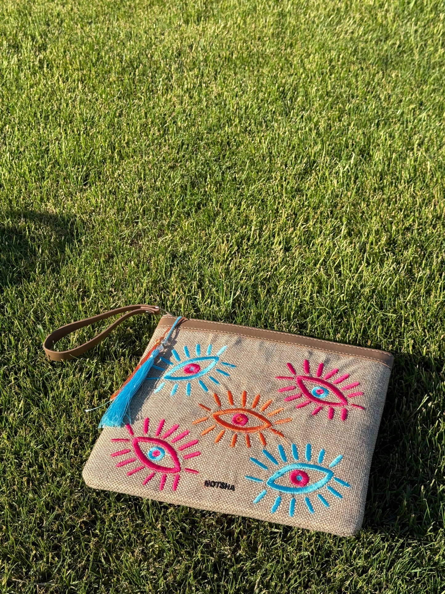 A modern twist on the classic evil eye blending baby blue, orange, and fuchsia.