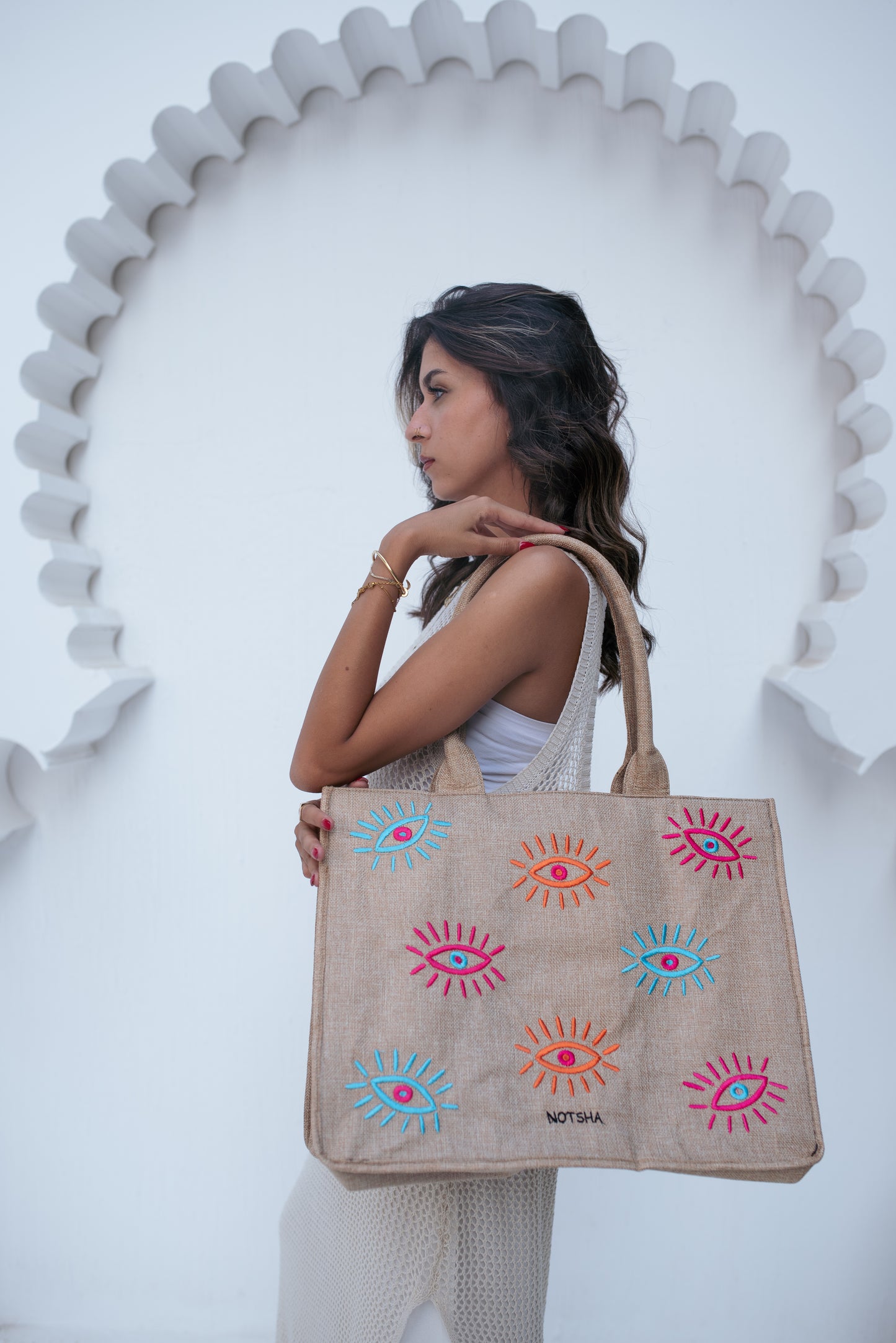 A modern twist on the classic evil eye blending baby blue, orange, and fuchsia.